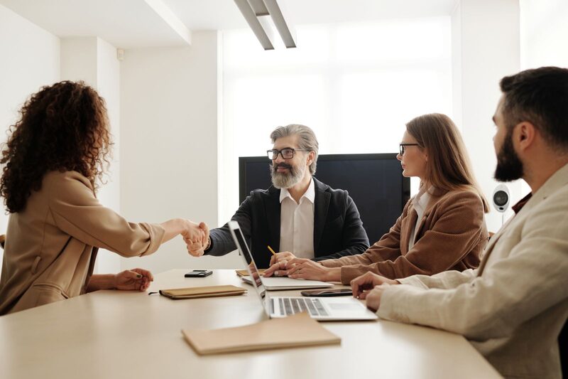 Hiring manager welcoming a new team member with a handshake in a Charlotte office