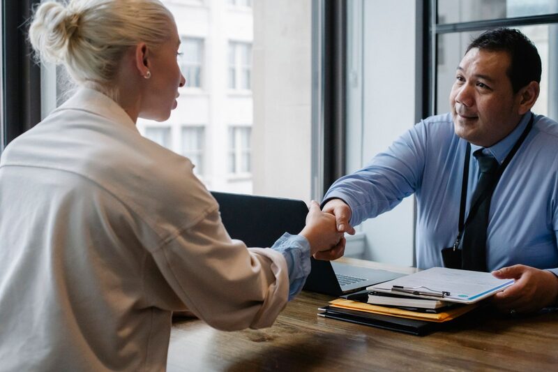 Hiring manager shaking hands with a candidate at the end of an interview