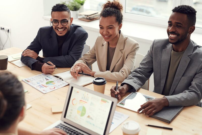 Three sales professionals reviewing campaign results together at a Charlotte office table