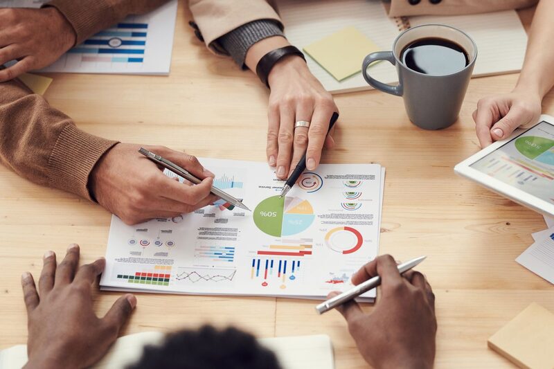Campaign performance reports and charts reviewed on a table during a client meeting